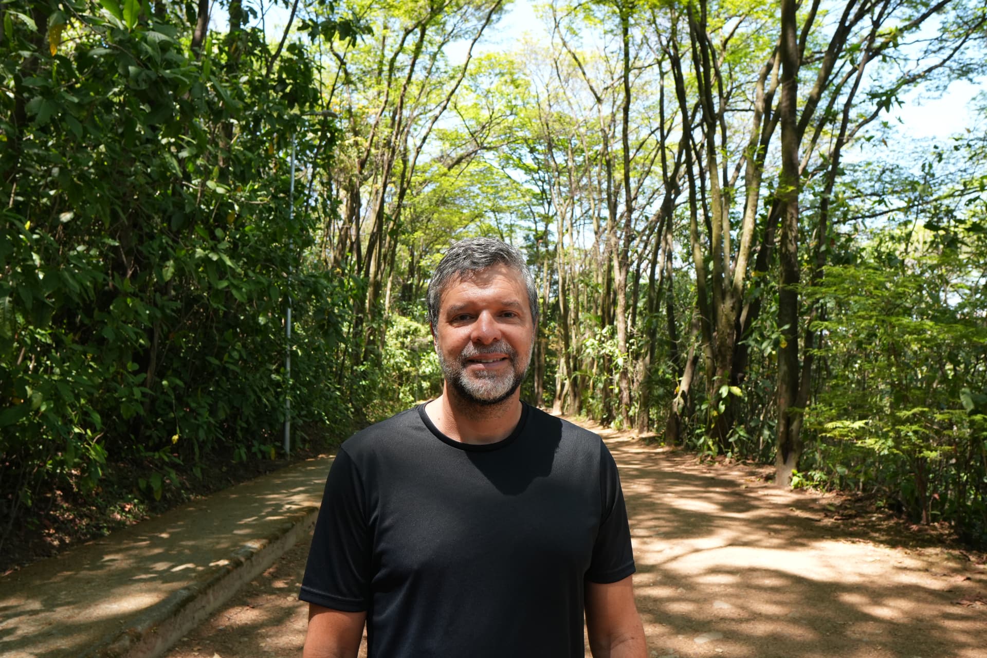 Retrato de Matheus Cautiero em uma alameda arborizada